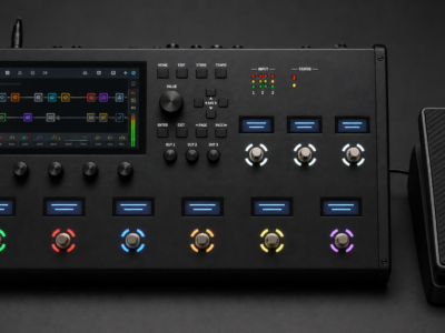 Concept-style photo of a black FM9-style guitar modeler with a touchscreen and separate expression pedal accessory.