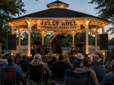 Satirical image of Jelly Roll performing near a backyard shed and gazebo setup.