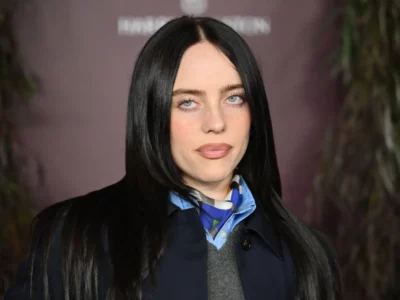 Billie Eilish looking at the camera with pale blue eyes and long black hair at an event.