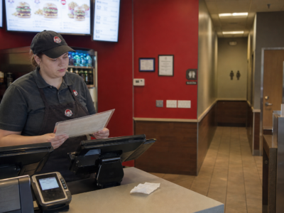 Fast-food counter with receipt and restroom hallway in background